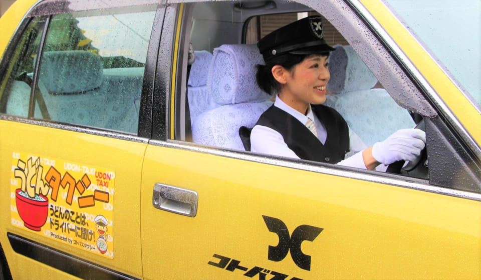 ※写真は「うどんタクシー」の女性ドライバーです。